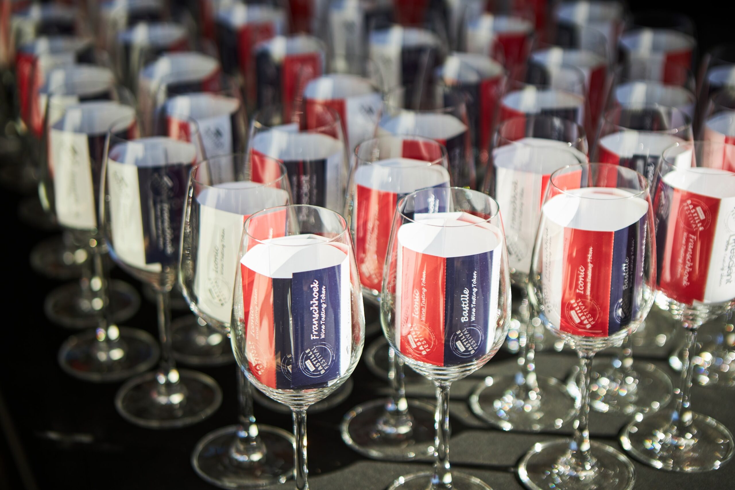 Wine glasses with red and blue labels for the Iconic Franschhoek Bastille Festival