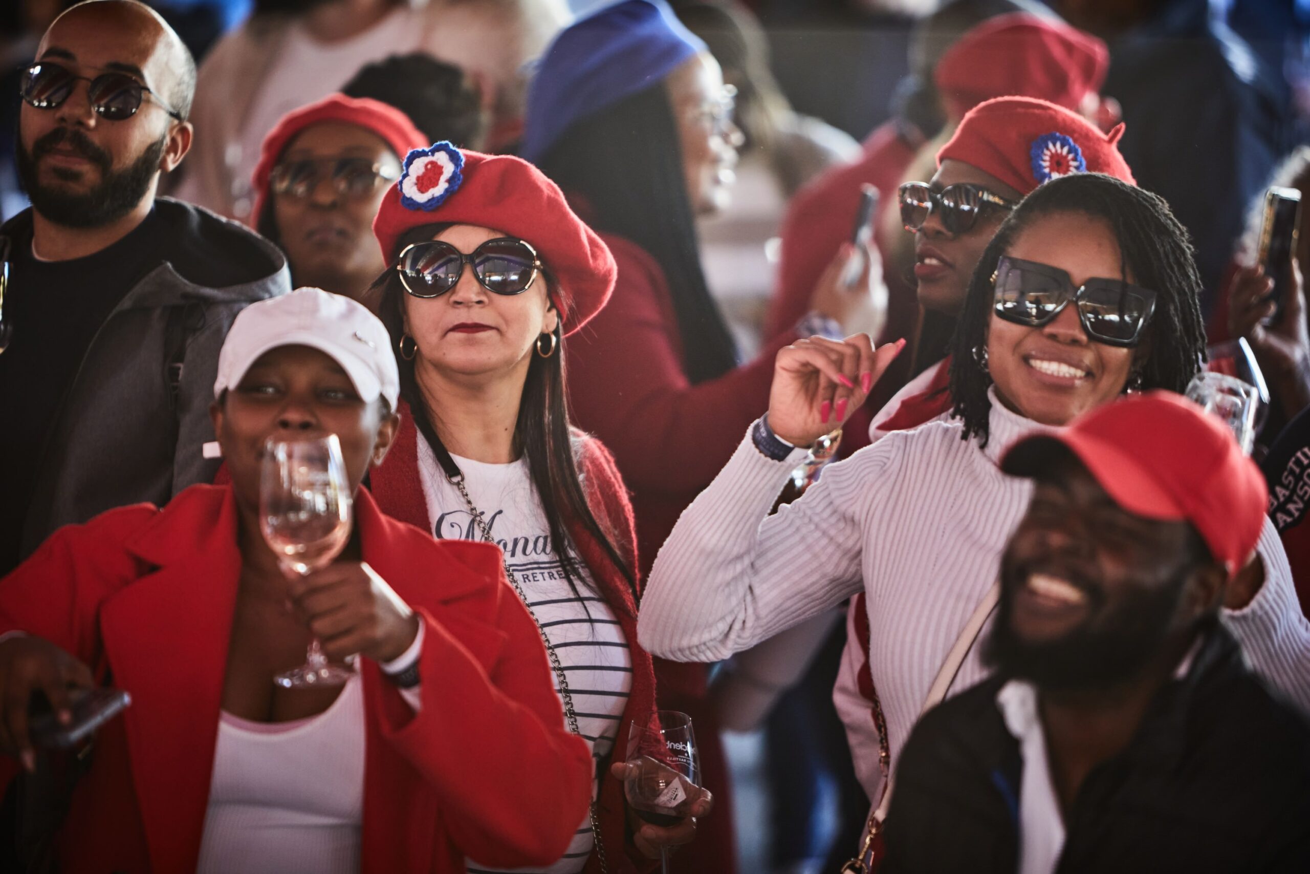 Diverse group of people in red hats and white tops dancing