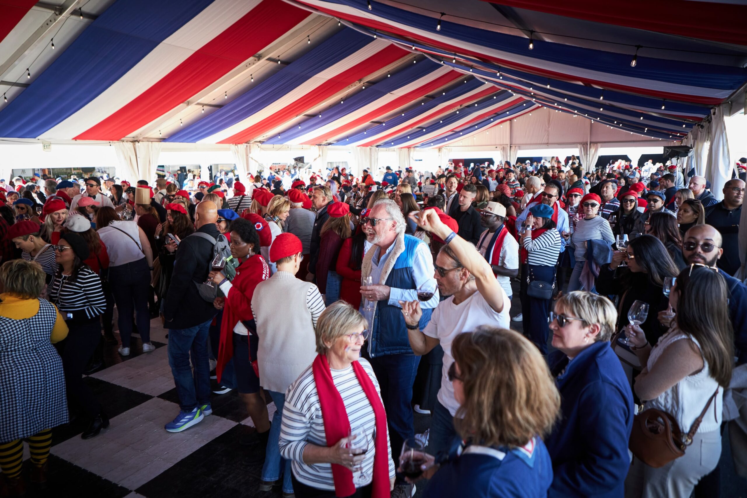 Crowd of people in a tent with red, white, and blue decorations